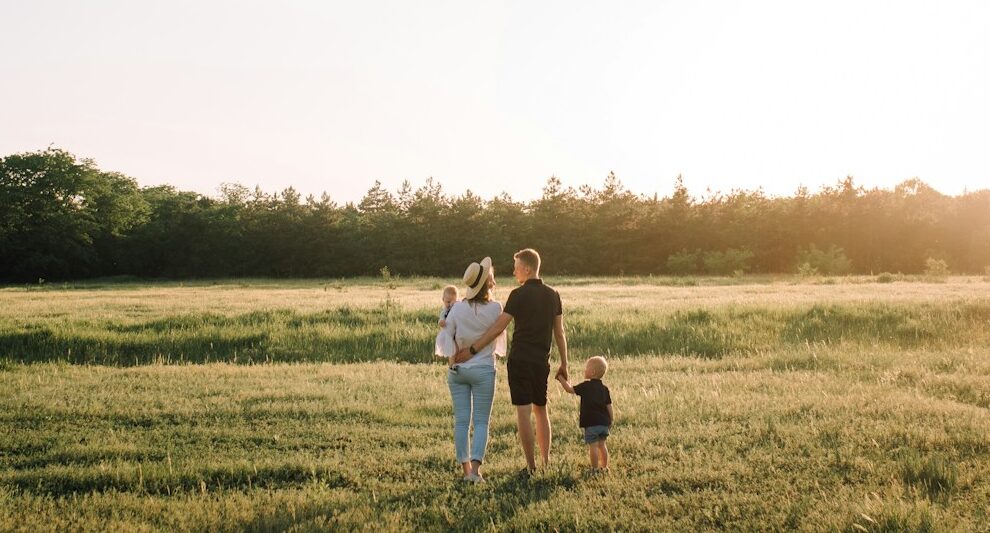 man and woman walking on green grass field during daytime